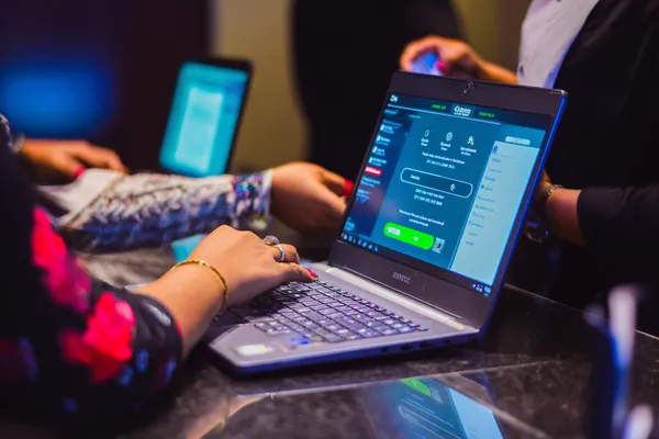 A confident dealer surrounded by casino chips inviting players to access their PARIPULSE account, reflecting quick and easy login options.